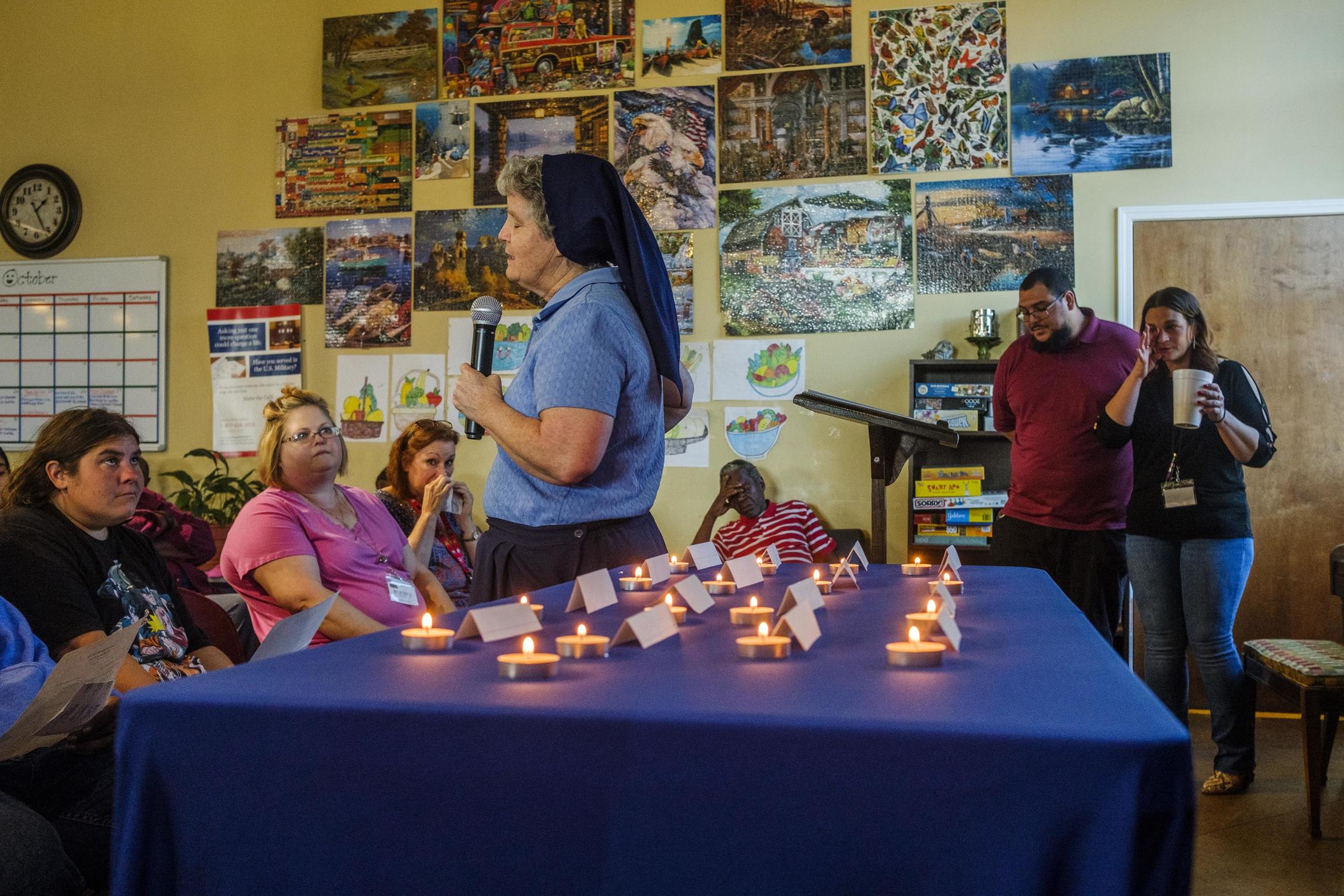 Sister Theresa Sullivan leads a memorial service for members of the unhoused community in Macon, Ga, each represented by a votive candle, during an annual memorial service at the Daybreak Resource Center this week. 