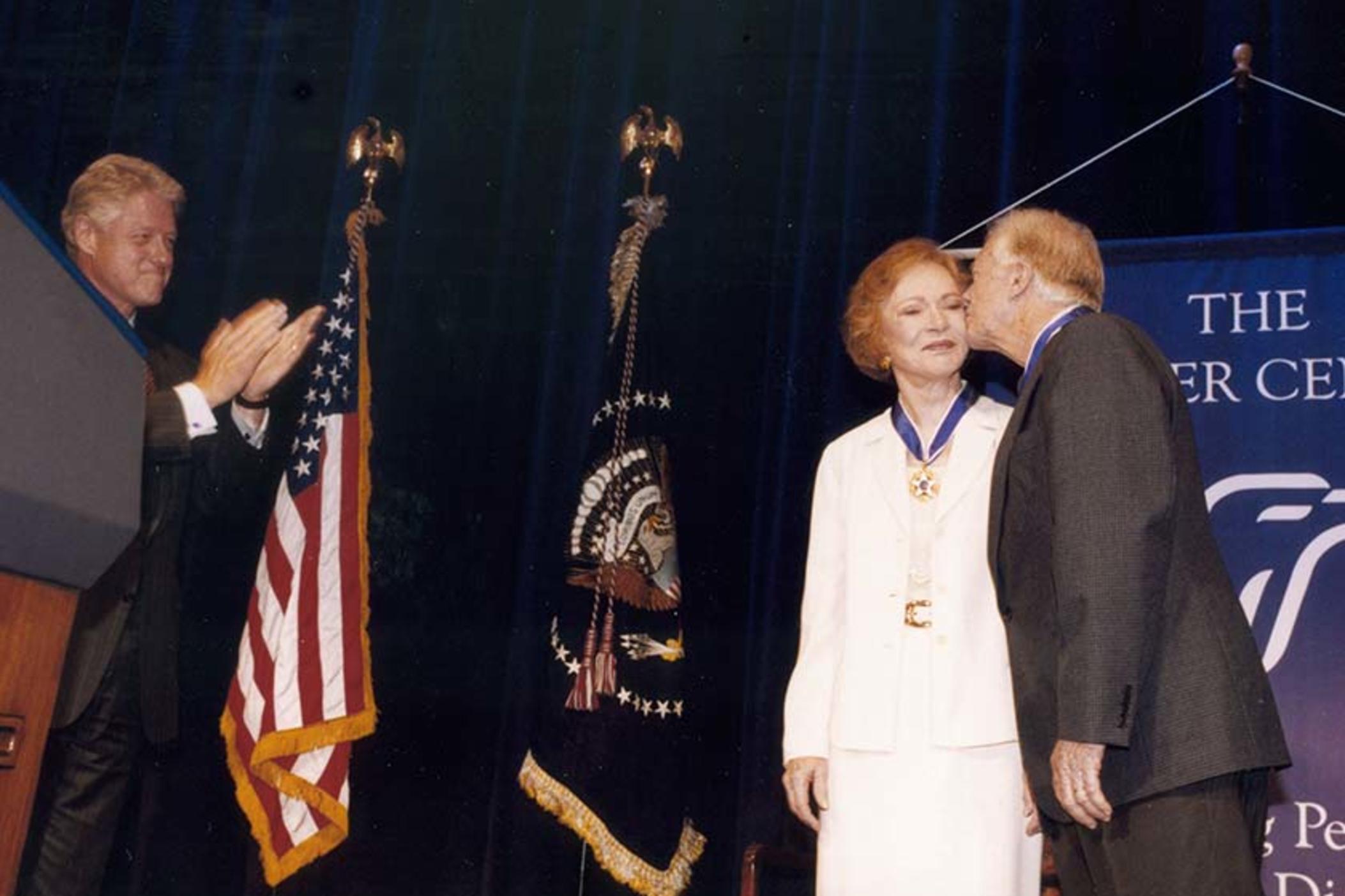 Former President Jimmy Carter and former First Lady Rosalynn Carter receive the Presidential Medal of Freedom from President Bill Clinton at a ceremony at The Carter Center in Atlanta, Georgia, August 9, 1999. 