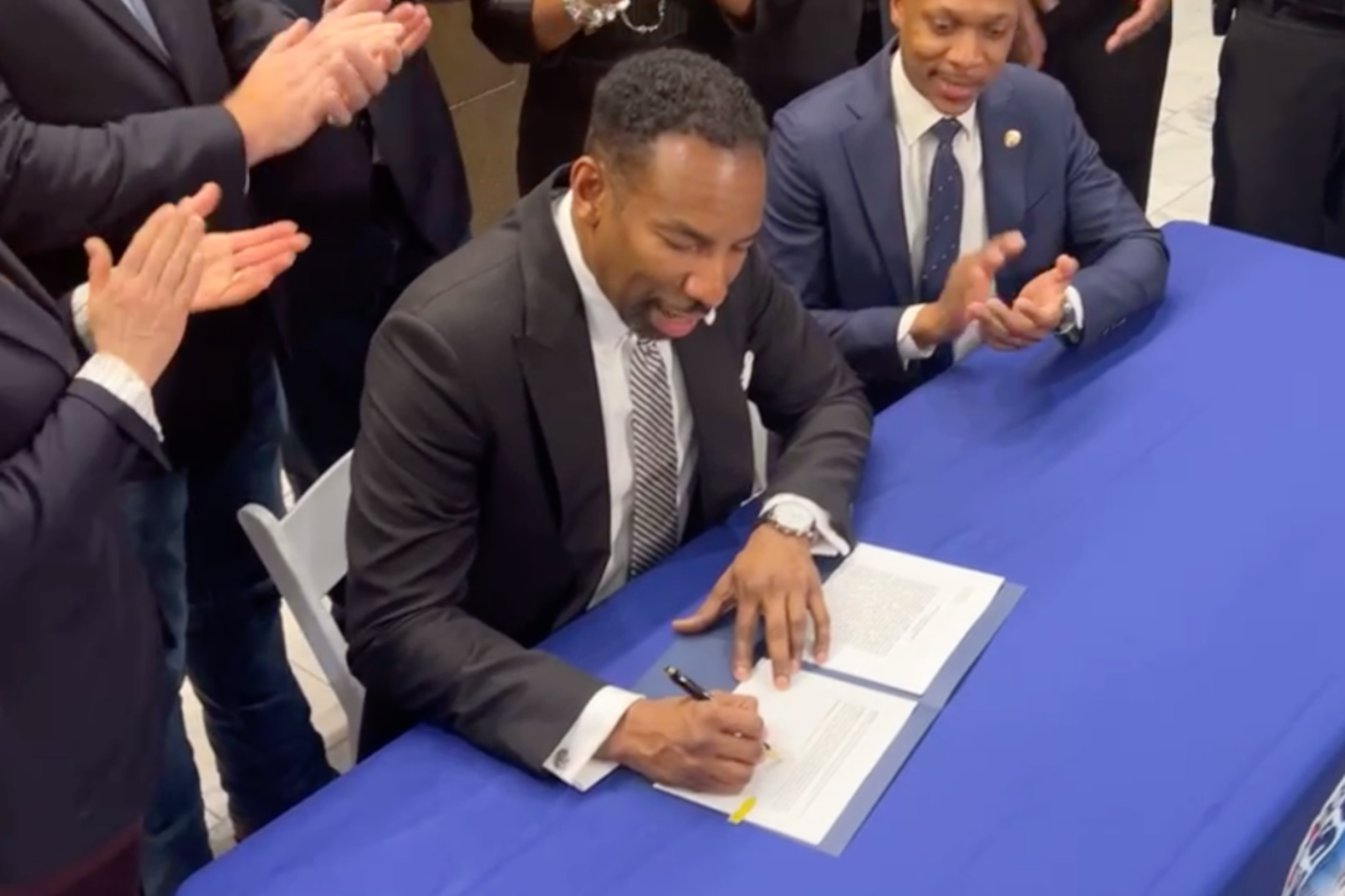 Atlanta City Councilmember Jason Winston looks on as Mayor Andre Dickens signs an executive order to utilize $4.6 million to help the city’s homeless population at a ceremony on Jan. 24 at city hall