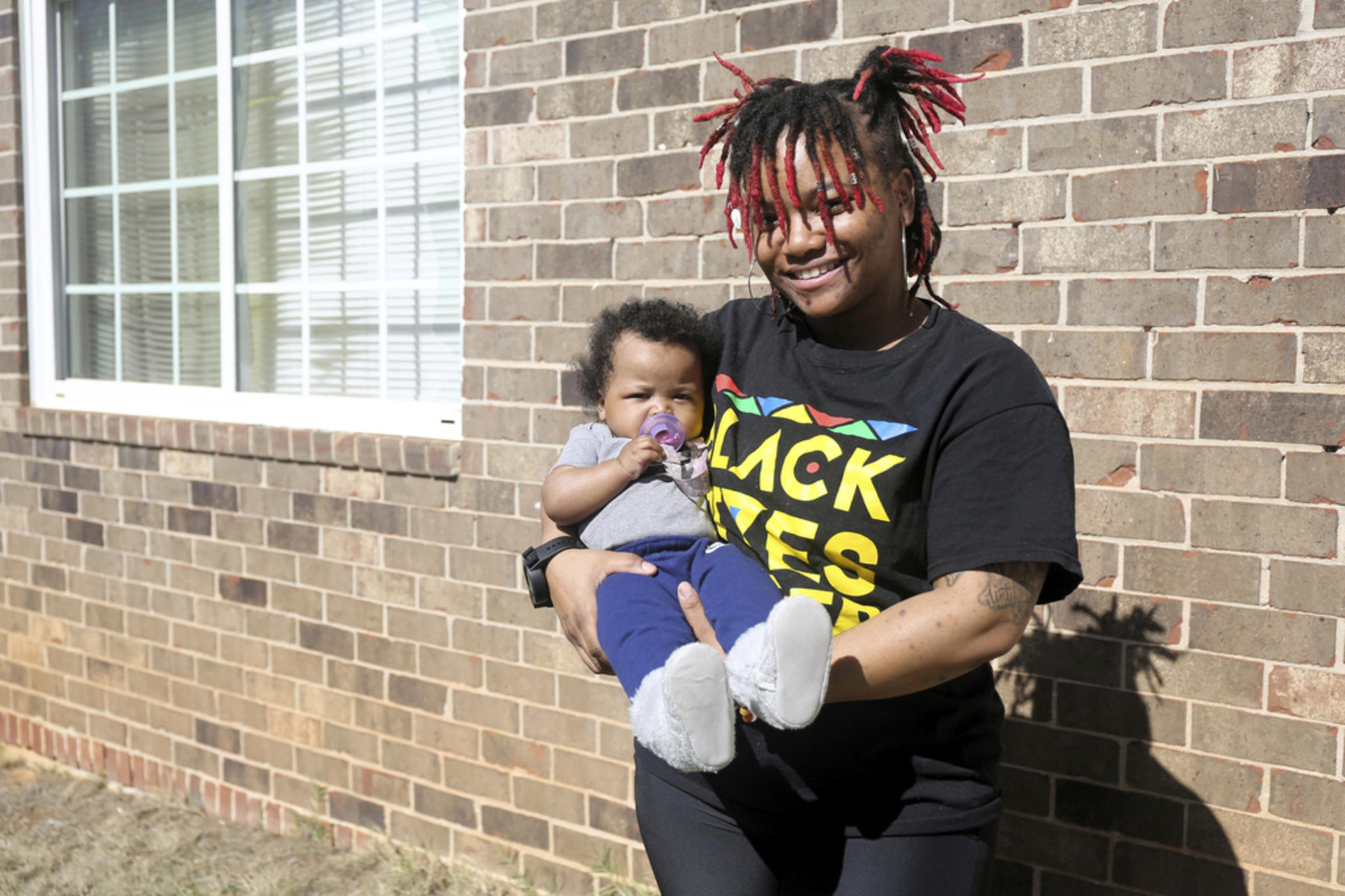 Nia Thomas stands in front of her Atlanta home on Feb. 14, 2024. Thomas was bailed out of jail by the nonprofit Barred Business in May 2022 through the “Mama’s Day Bail Out,” initiative, a practice that could be significantly restricted, if not criminalized, under a recently passed Georgia bill. (AP Photo/R.J. Rico)