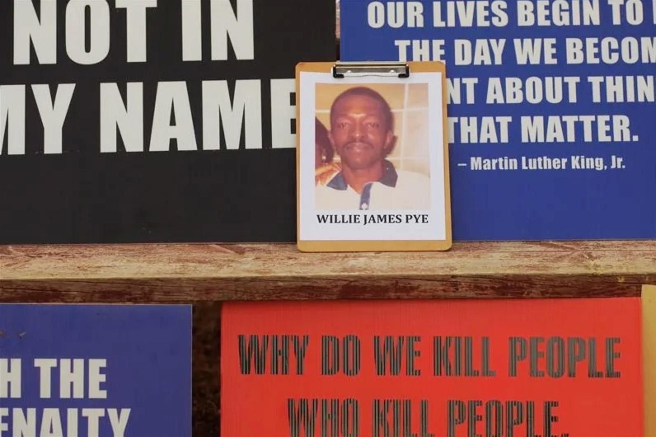 A photo of Willie Pye among the posters of death penalty opponents outside Georgia Diagnostic Prison during Pye's execution. 