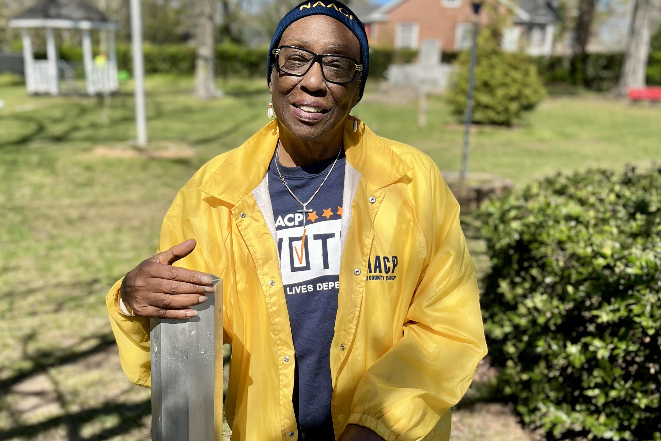 Donetta Smith stands with the pole where the lynching marker to Reuban Hudson was installed