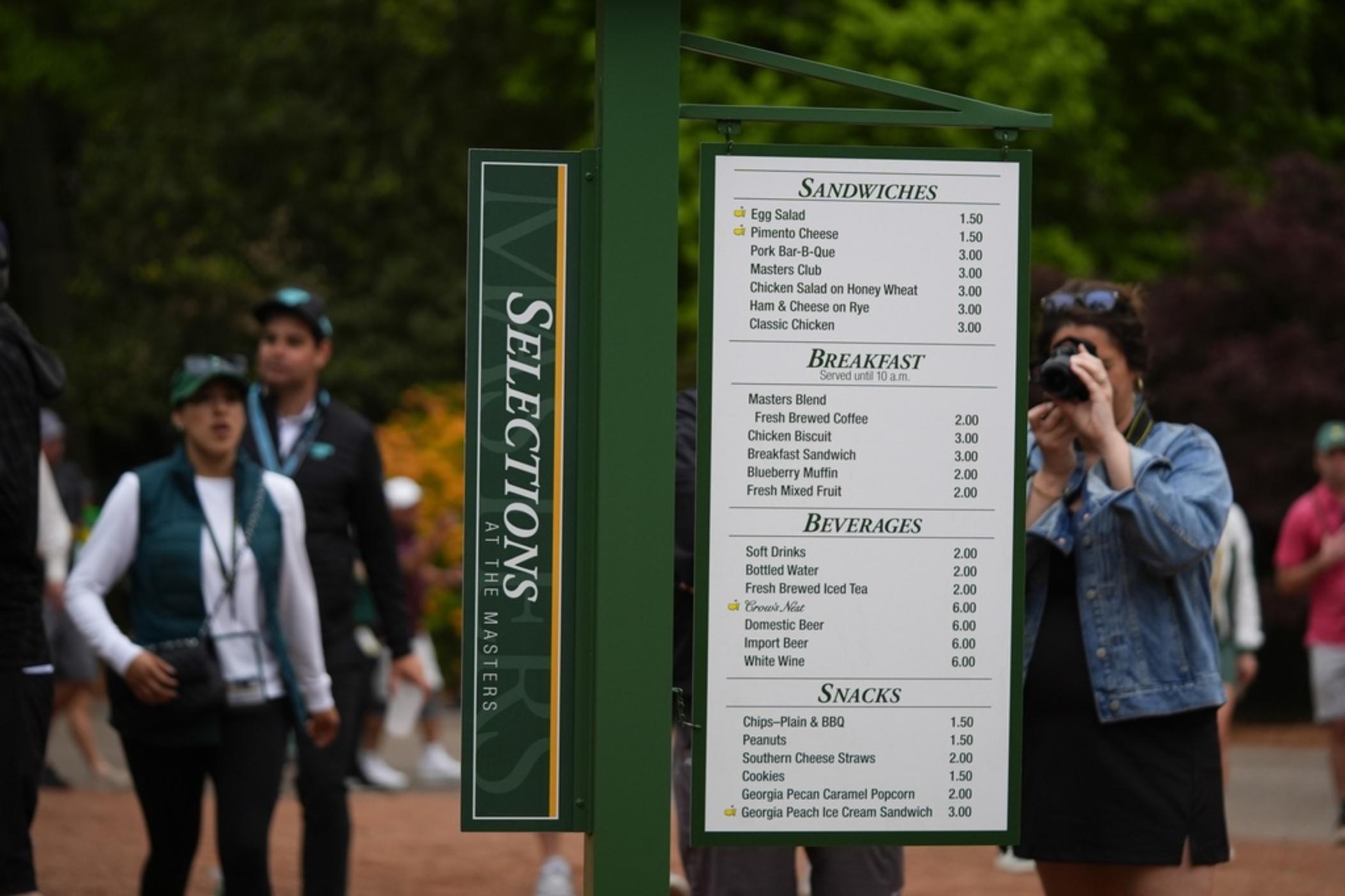 Patrons view the prices of food items on a board during a practice round in preparation for the Masters golf tournament at Augusta National Golf Club Tuesday, April 9, 2024, in Augusta, Ga. 