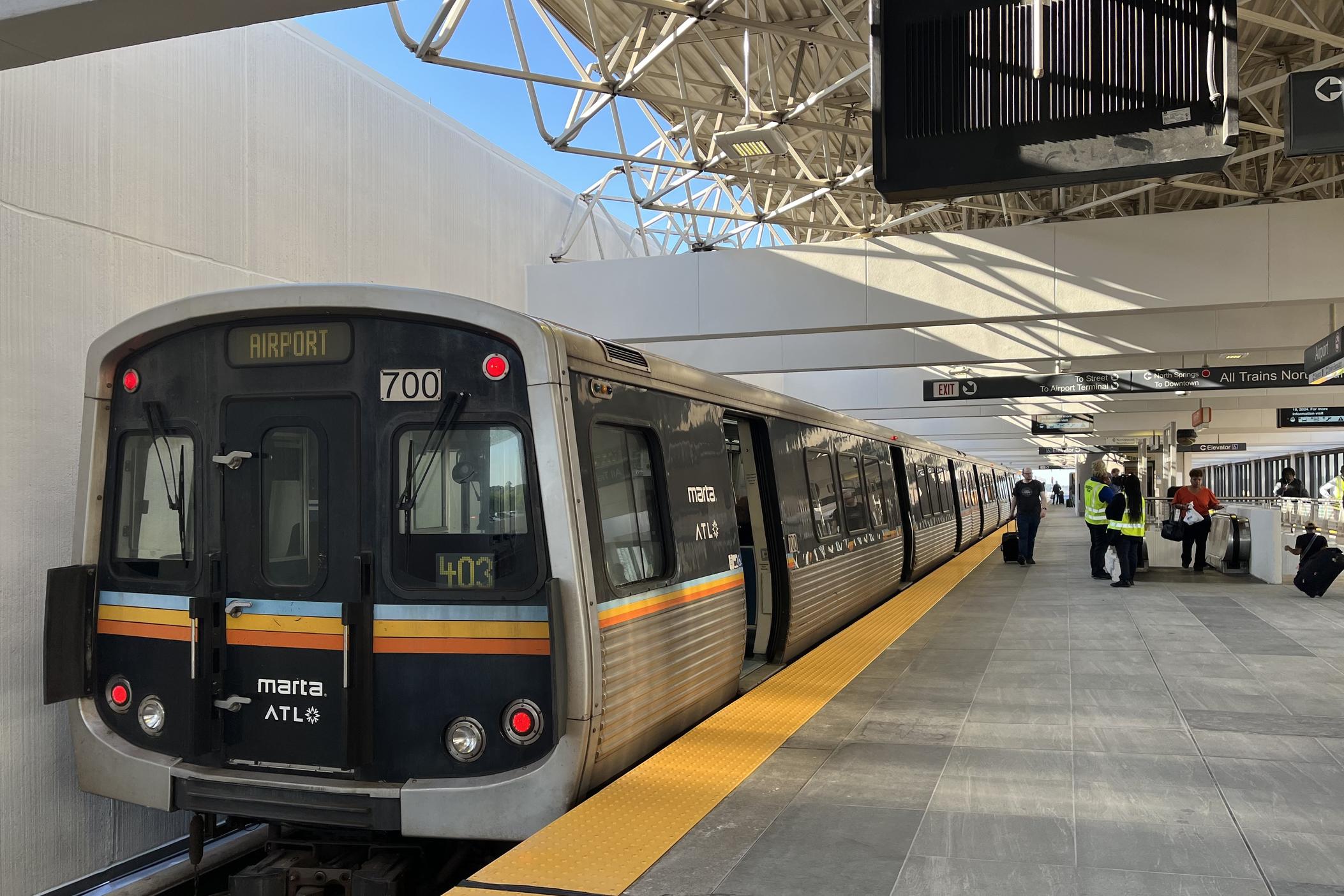 MARTA train stopped at the aiport station. A yellow tactile line can be seen on the edge of the platform and new gray tiling.