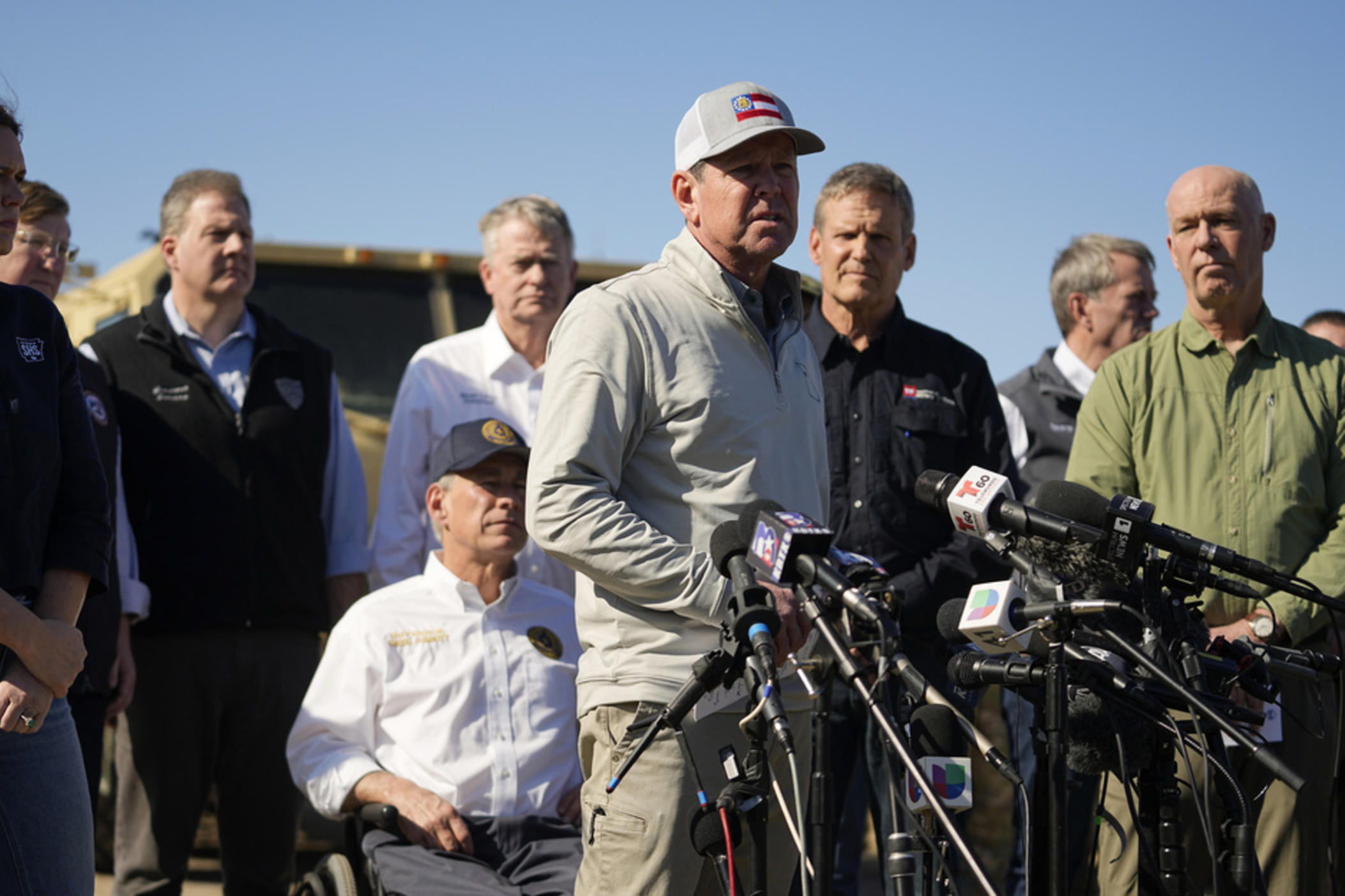 Texas Gov. Greg Abbott, seated center, listens as Georgia Gov. Brian Kemp, center, speaks during a news conference along the Rio Grande to discuss Operation Lone Star and border concerns, Sunday, Feb. 4, 2024, in Eagle Pass, Texas.
