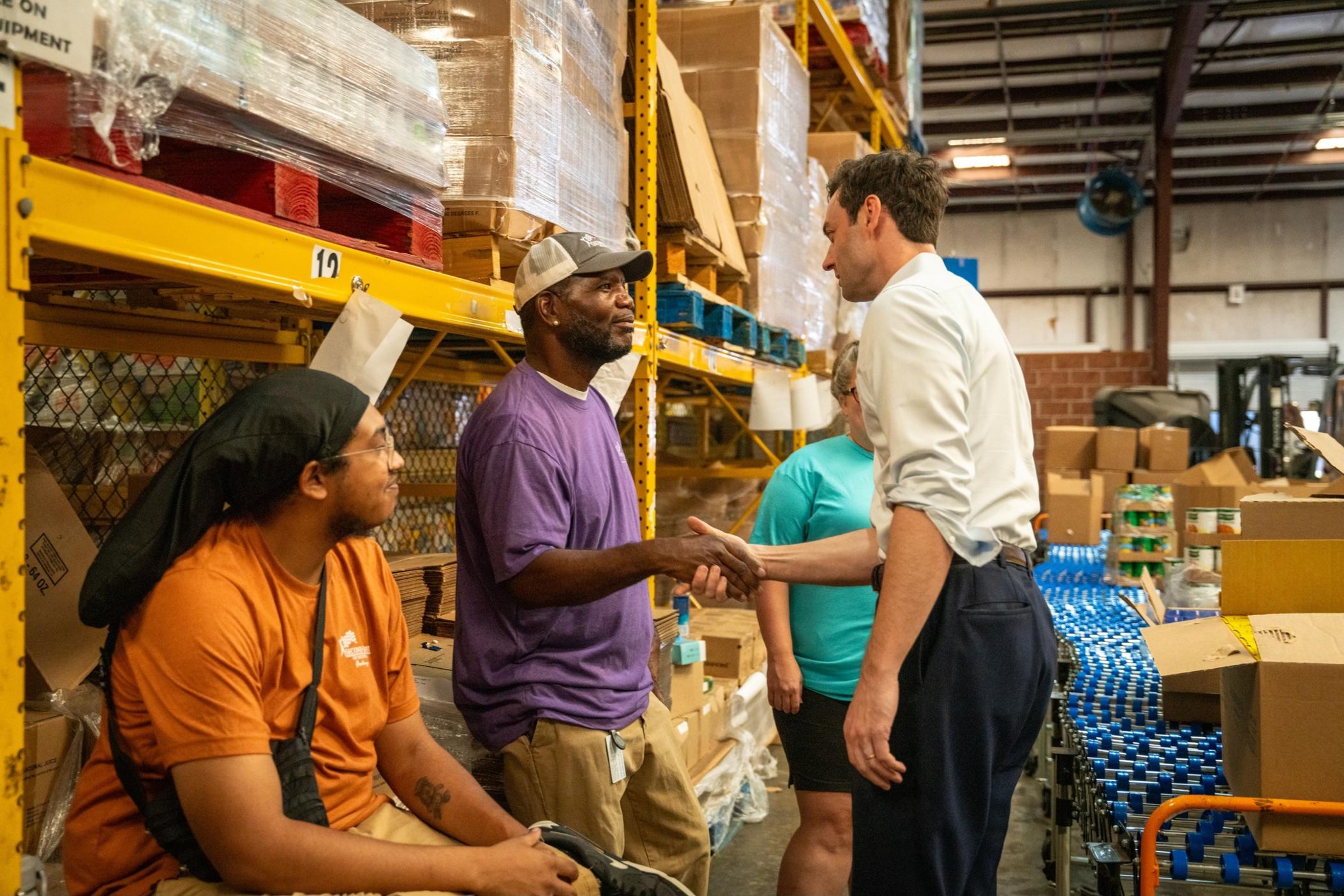 Sen. Jon Ossoff (right) greets employees and volunteers at Second Harvest of South Georgia in Valdosta before distributing food to families affected by Hurricane Helene on Sept. 28, 2024.