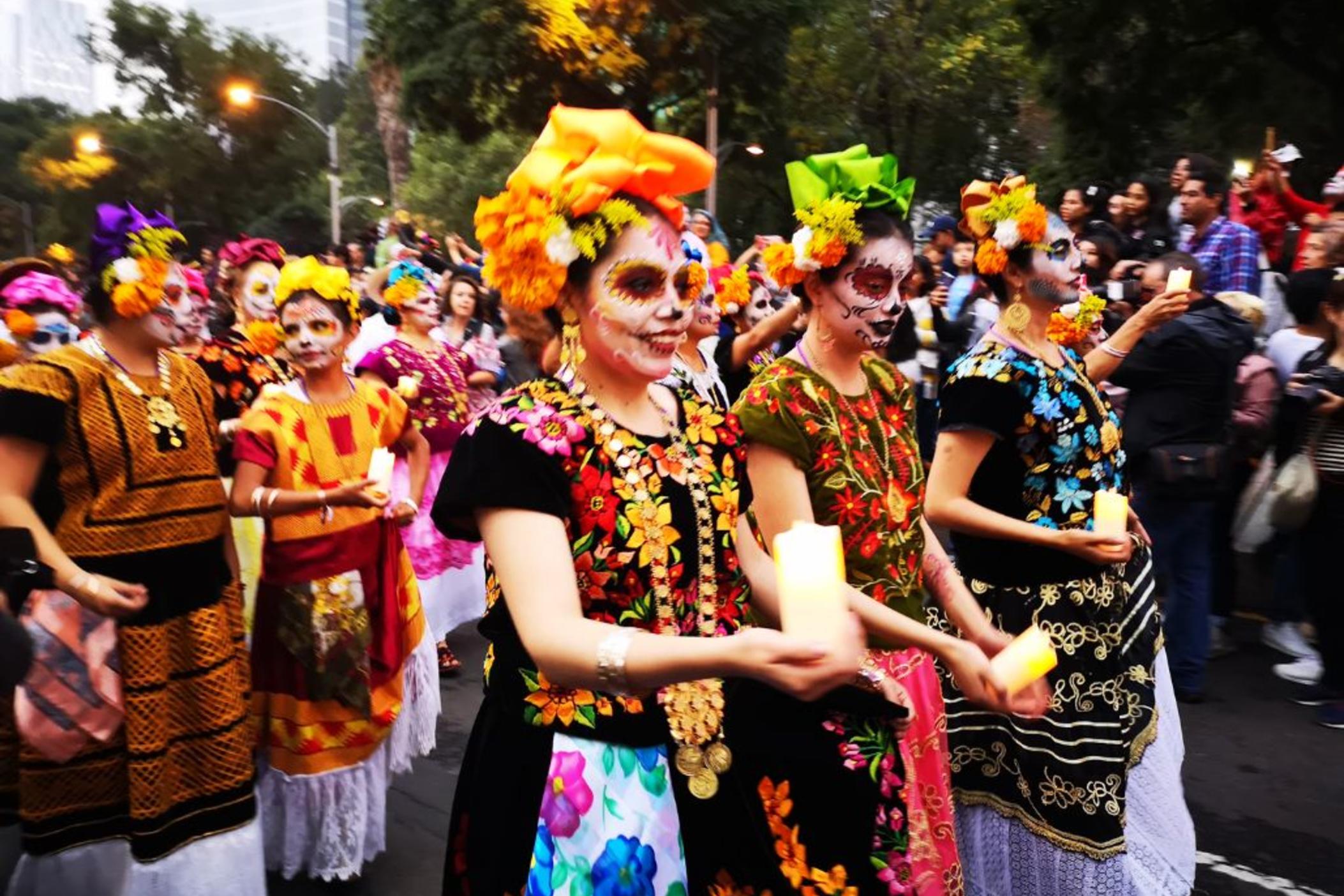 People celebrate Día de los Muertos at a parade.