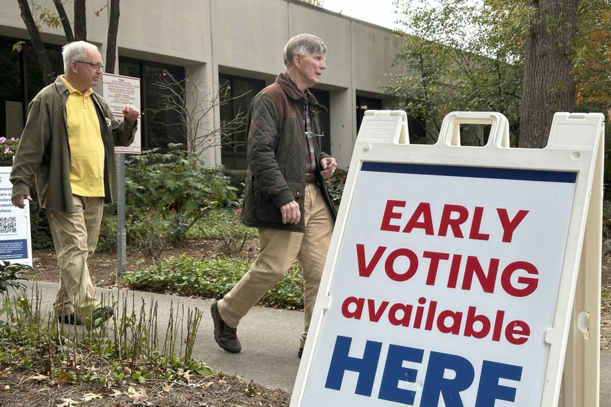 People leave after voting in the Atlanta suburb of Sandy Springs, Ga., on Tuesday, Oct. 15, 2024, the first day of early in-person voting in Georgia. 