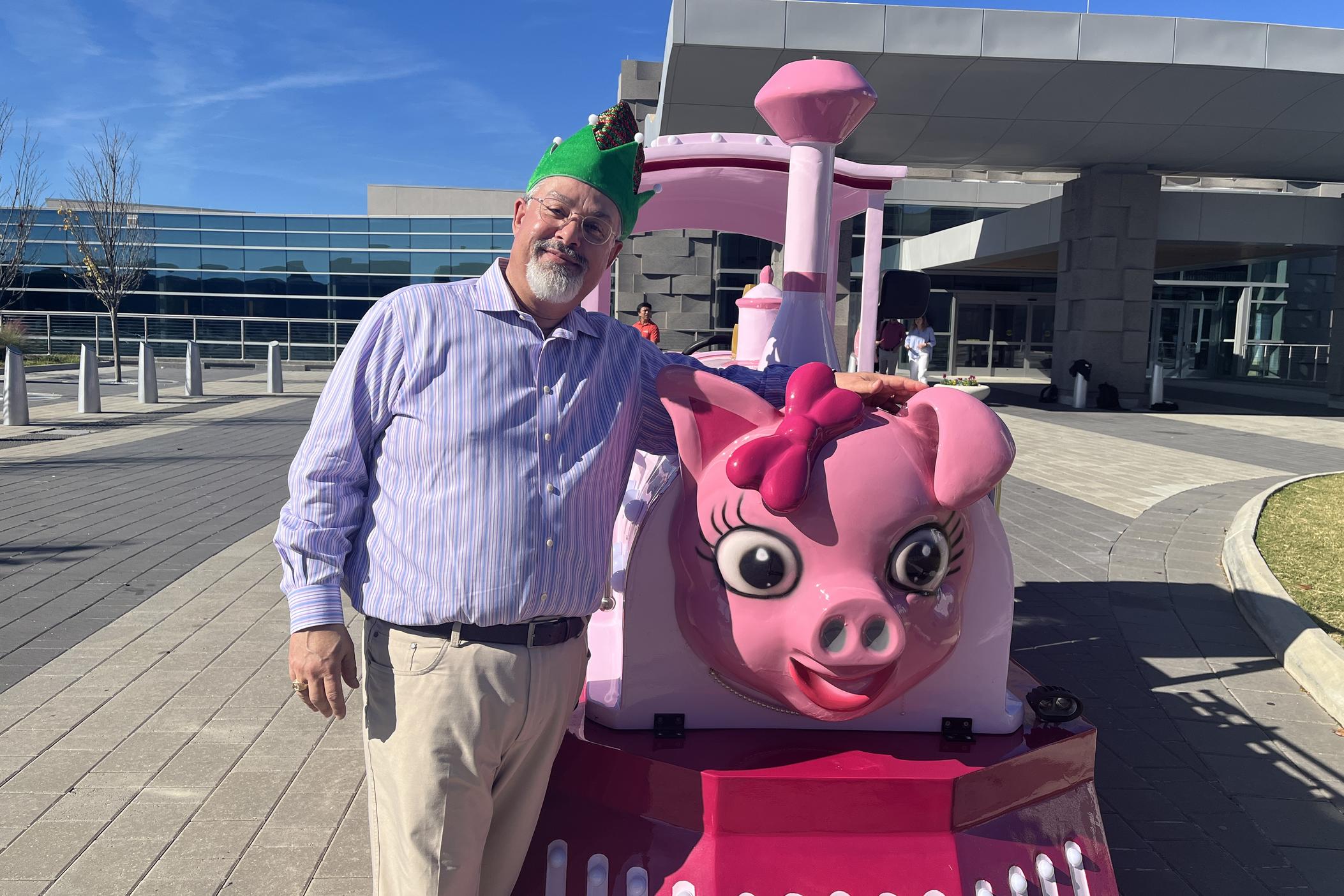 Head Elf Waffles McSnowflake poses with the new Pink Pig train, Penny.
