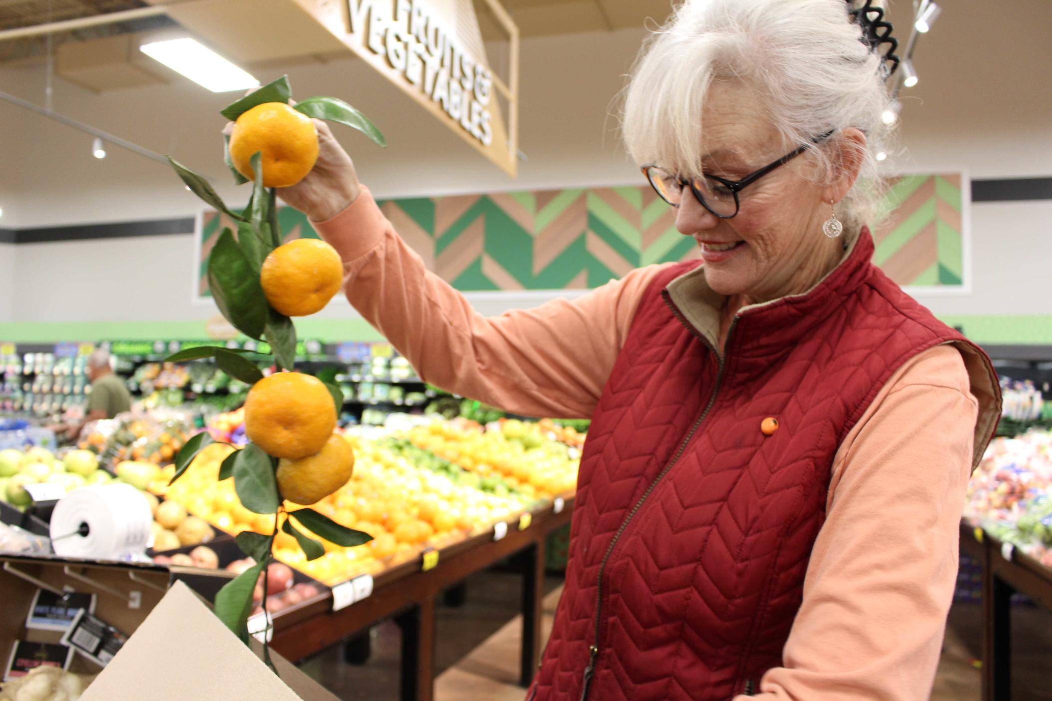 Lindy Savelle holds citrus fruit from her farm in a Kroger in Houston County, Georgia.