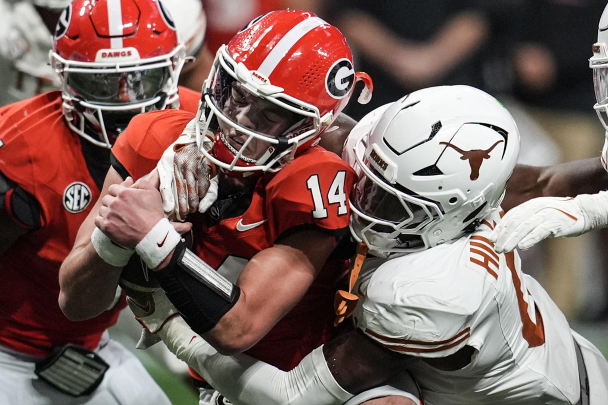 Texas linebacker Anthony Hill Jr. (0) hits Georgia quarterback Gunner Stockton (14) during the second half of the Southeastern Conference championship NCAA college football game, Saturday, Dec. 7, 2024, in Atlanta. 