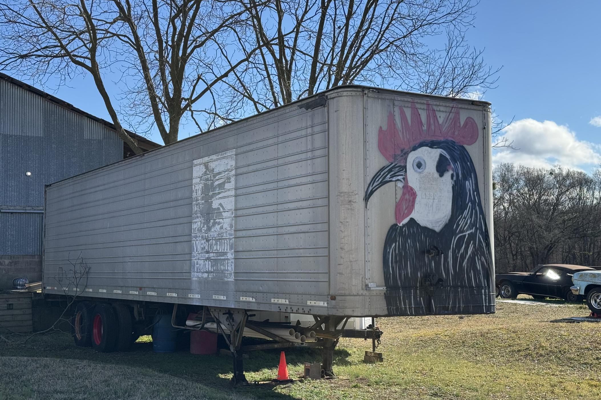 A mural of a rooster painted on a semi-truck trailer.