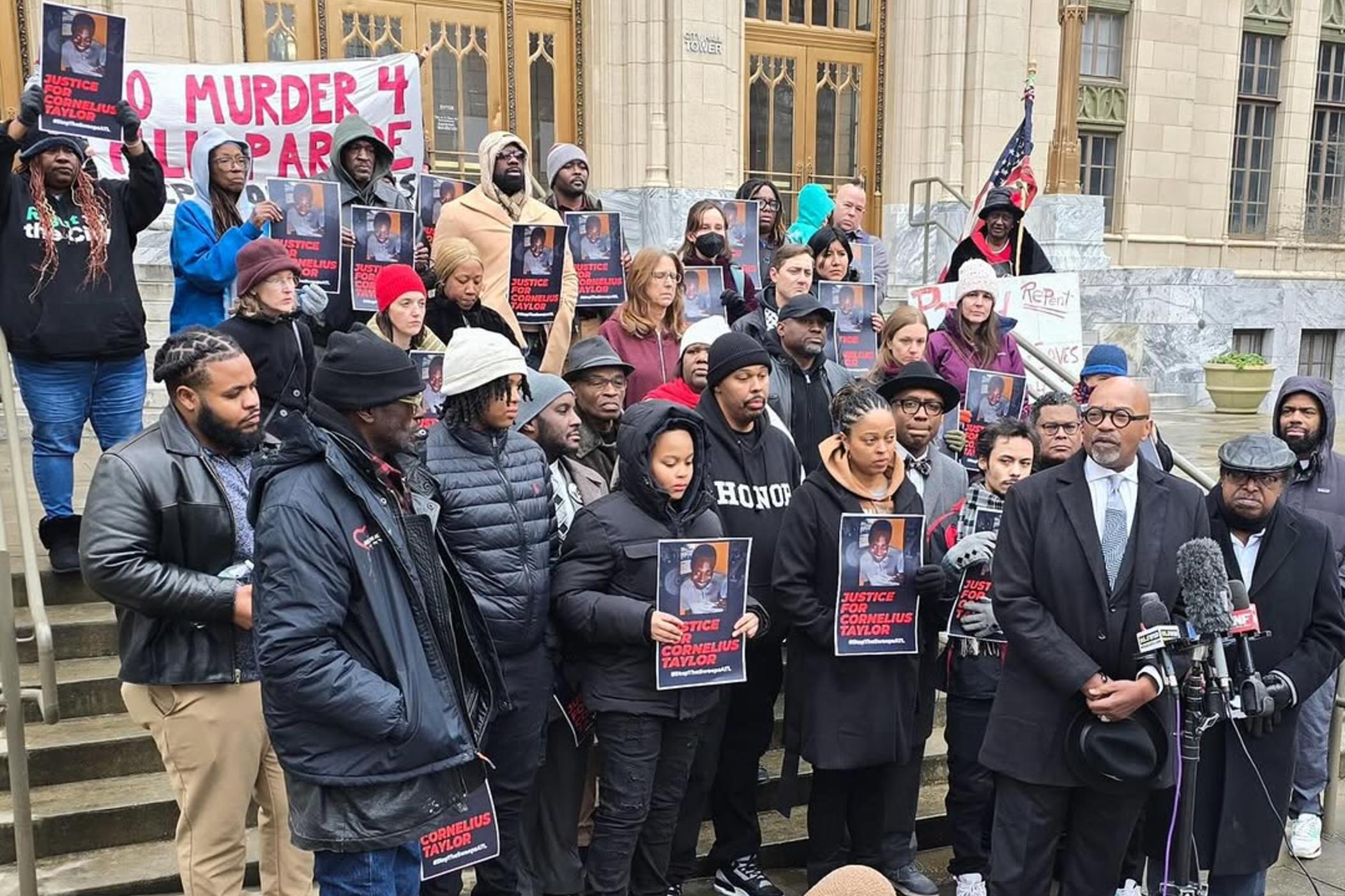 Activists gather on the steps outside Atlanta City Hall carrying signs saying 'justice for cornelius taylor' who was killed in a homeless encampment sweep in January 2025.