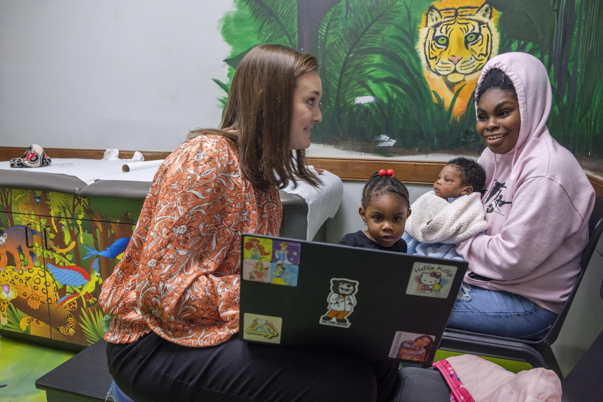 Pediatrician Brittany Lord, left, talks with Mahogany Brown about her infant son Memphis Exum’s health before a standard round of vaccinations during a recent visit in Lord’s practice in the town of Eastman.