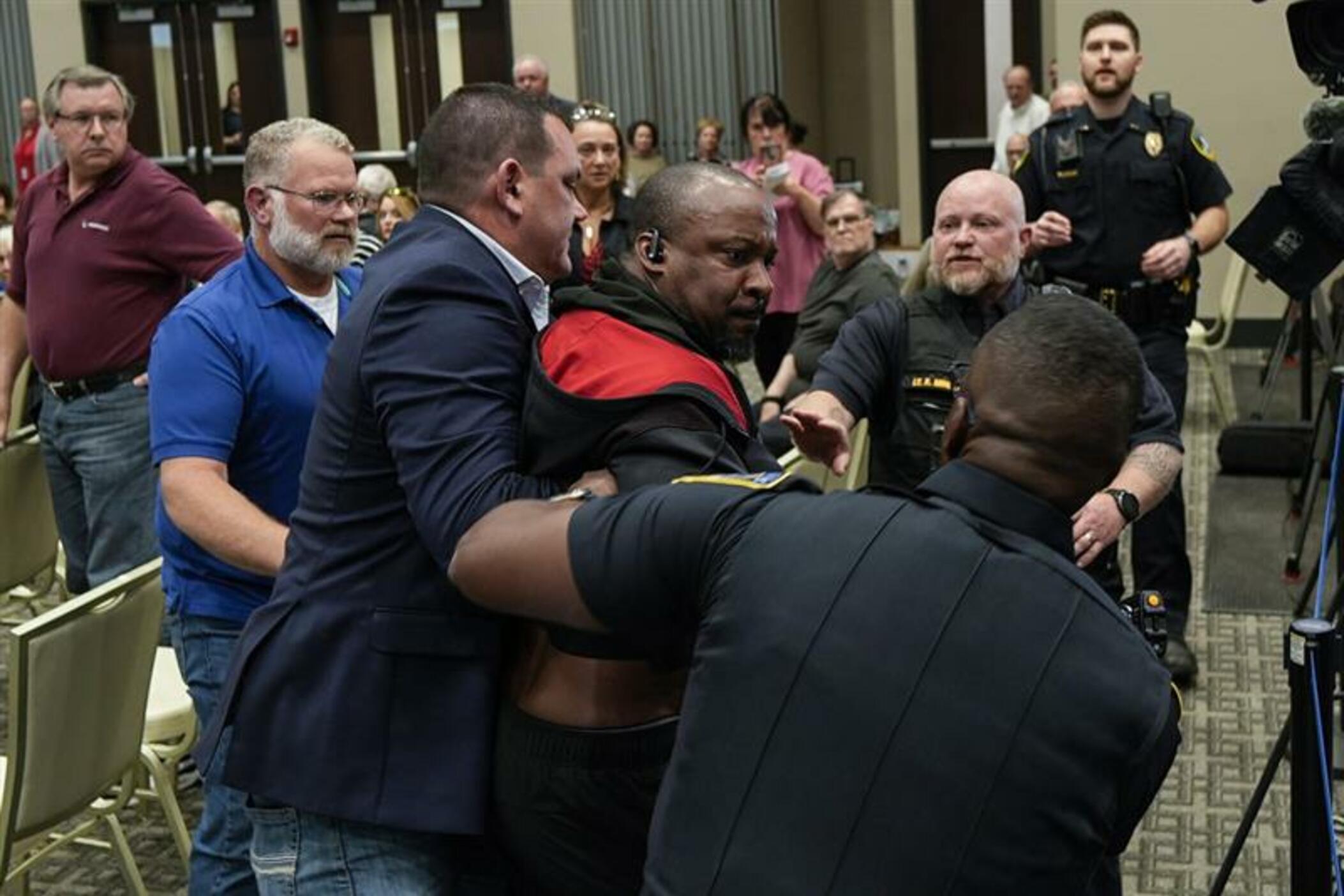 A protester is removed before a electronic non-leathal device was used as Rep. Marjorie Taylor Greene, R-Ga., speaks during a town-hall style meeting, Tuesday, April 15, 2025, in Acworth, Ga. (AP Photo/Mike Stewart)