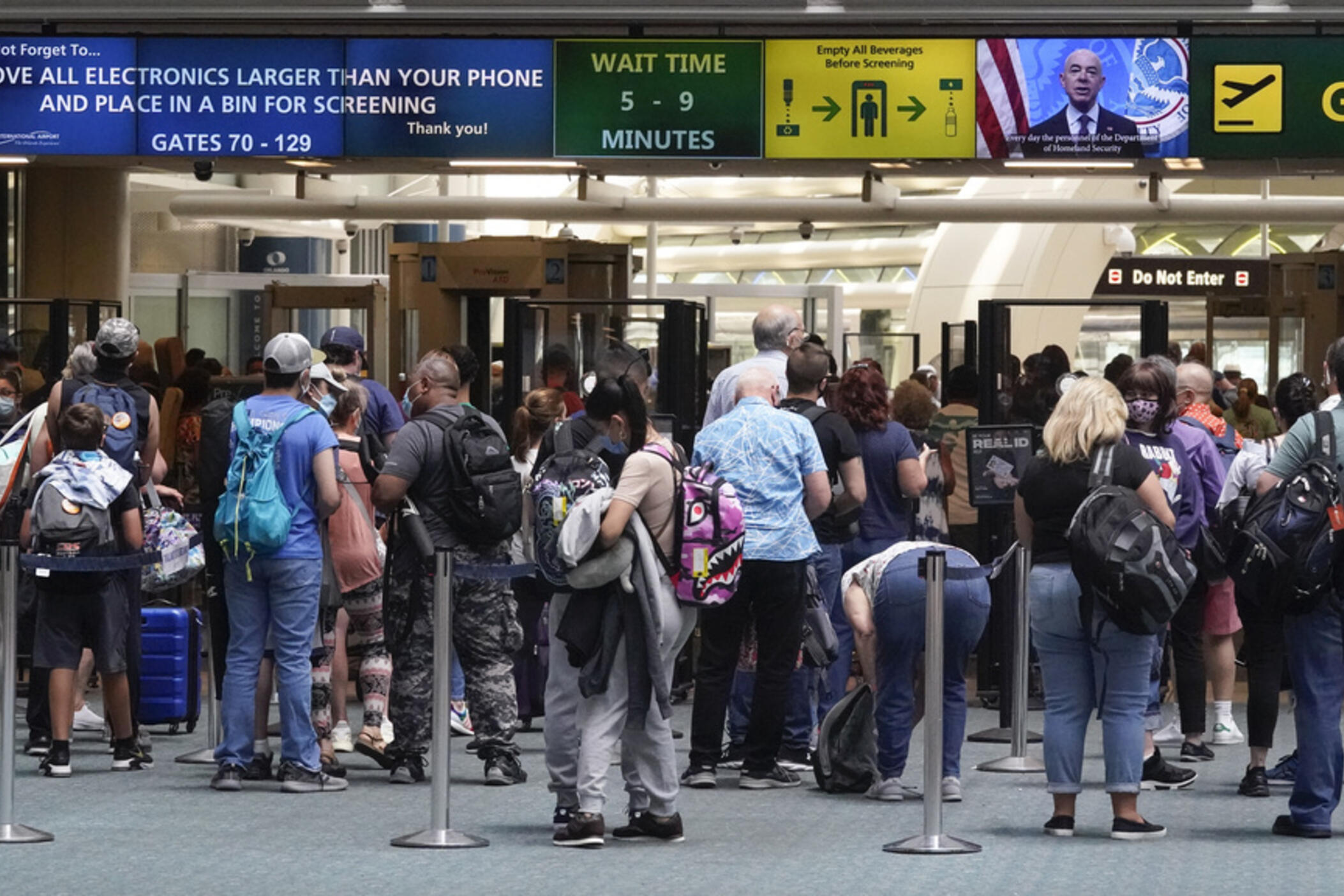 Travelers line up to go through a TSA checkpoint at Orlando International Airport before the Memorial Day weekend, May 28, 2021, in Orlando, Fla. (AP Photo/John Raoux, File)
