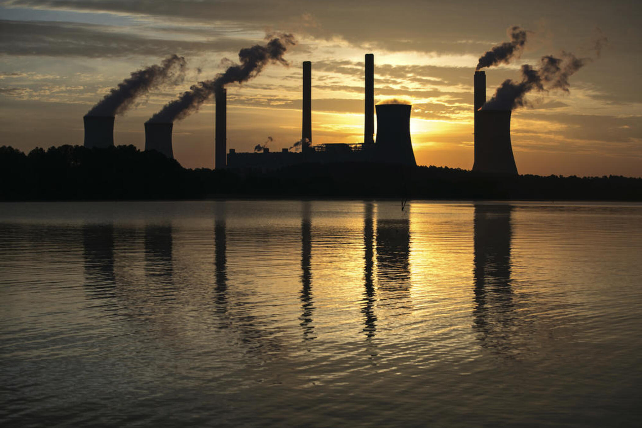 FILE - In this June 3, 2017, file photo, the coal-fired Plant Scherer, one of the nation's top carbon dioxide emitters, stands in the distance in Juliette, Ga. Global carbon dioxide emissions related to energy use are being forecast to rise significantly this year, driven by a resurgence in the use of coal to generate electricity, the International Energy Agency says. The IEA