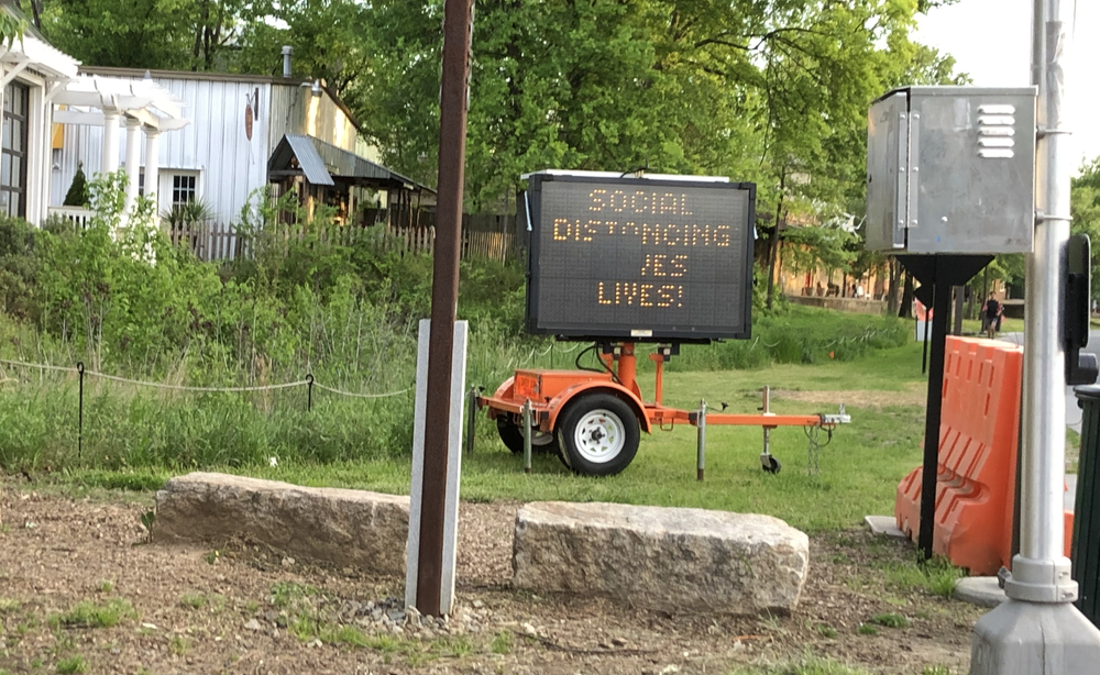 A sign near the Atlanta Belt Line reads "Social Distancing Saves Lives!"