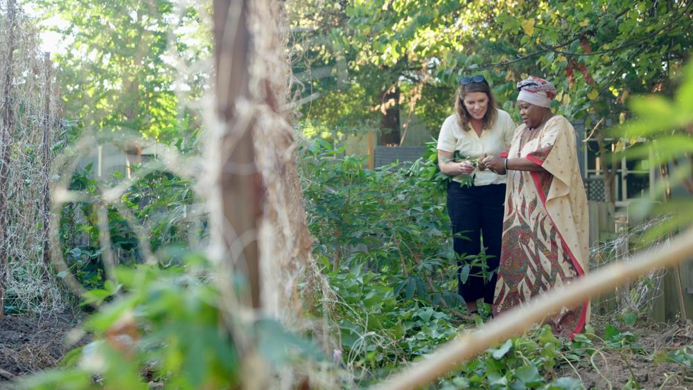 Farmer Halieth Hatungimana (right) shows a cassava root to chef Vivian Howard at The Burundi Women's Farm, a project of the Global Growers Network in Decatur.