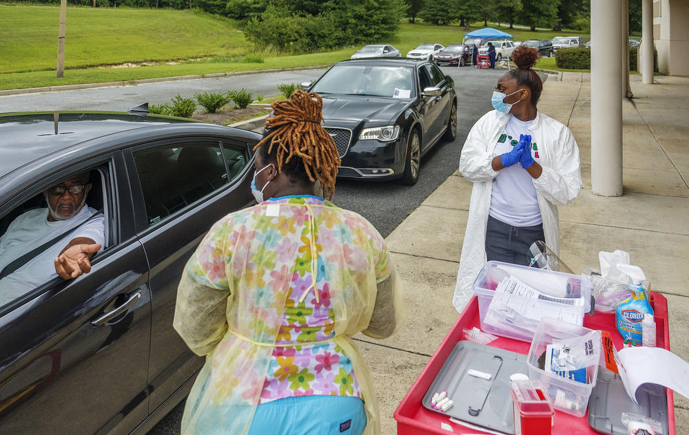 Healthcare workers administer Coronavirus test at drive-thru testing site in Macon