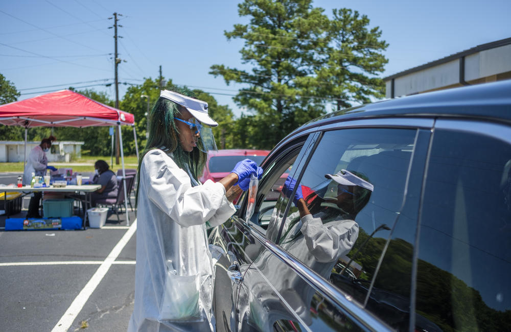 A Healthcare worker closes a plastic bag containing a coronavirus test kit