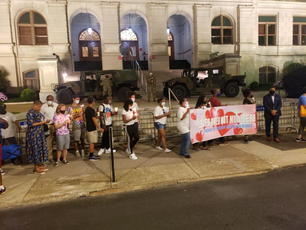 Protesters march at the Georgia State Capitol as National Guard troops look on.