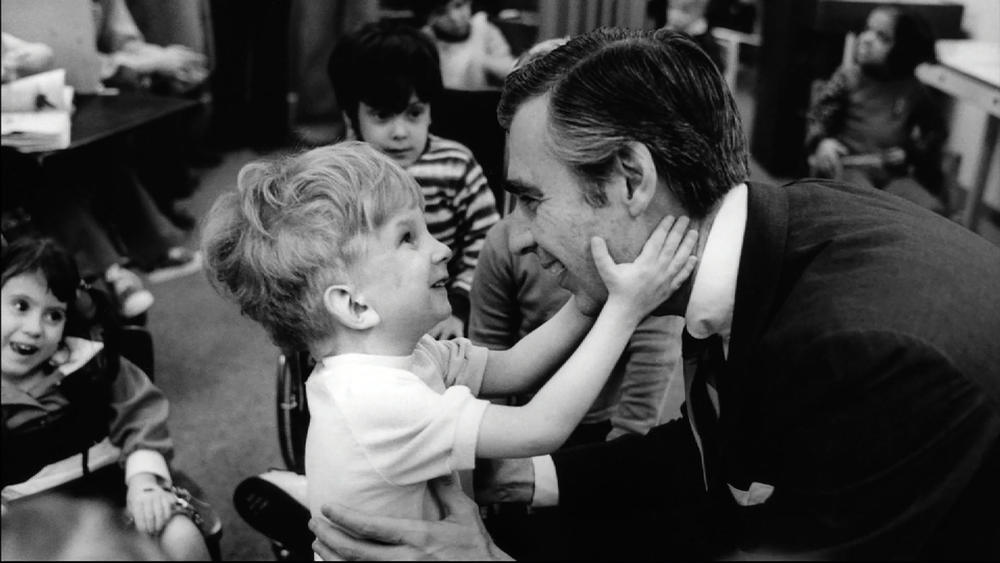 Fred Rogers and a young child.