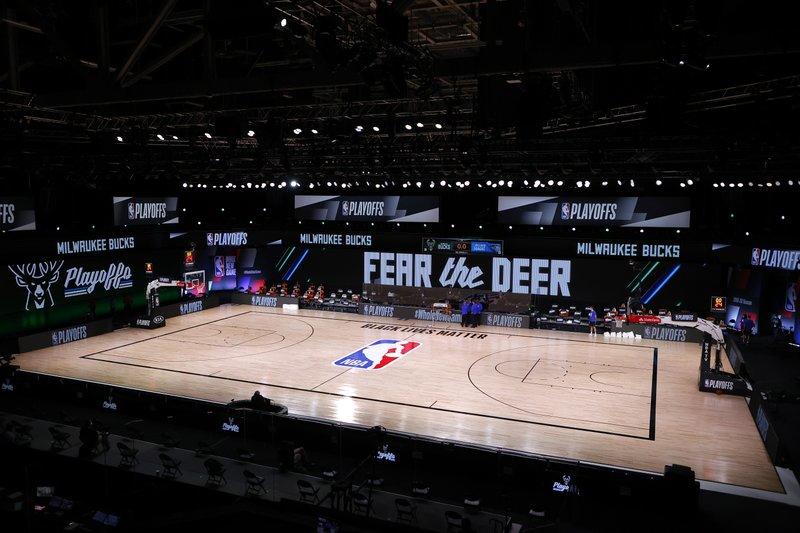 Referees huddle on an empty court at game time of the scheduled fifth game of the first round NBA playoff series between the Milwaukee Bucks and the Orlando Magic, Wednesday, Aug. 26, 2020, in Lake Buena Vista, Fla.