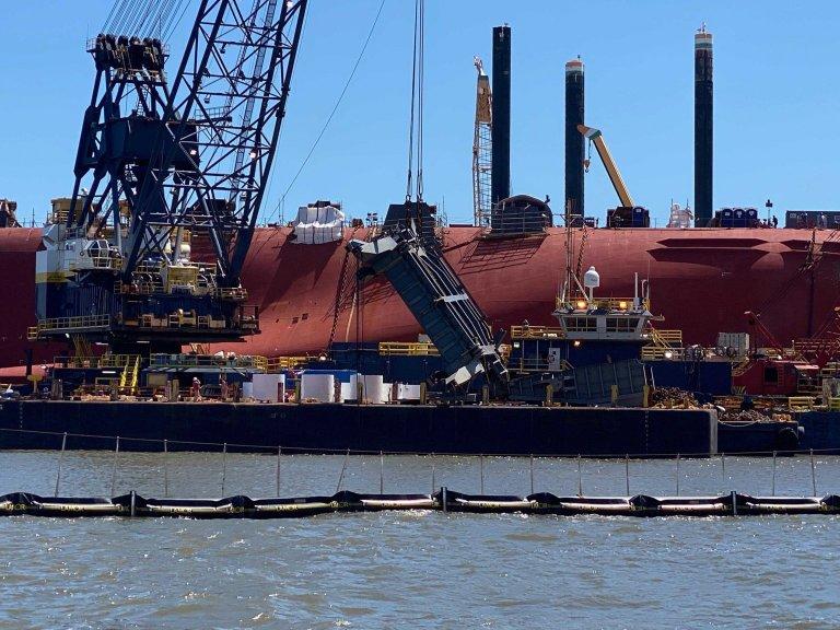 A salvage crew used a crane on June 24 to hoist a section of the Golden Ray's ramp used to load vehicles on and off the ship. The Coast Guard is delaying the ship’s removal from St. Simons Sound until at least October to avoid the peak of hurricane season.