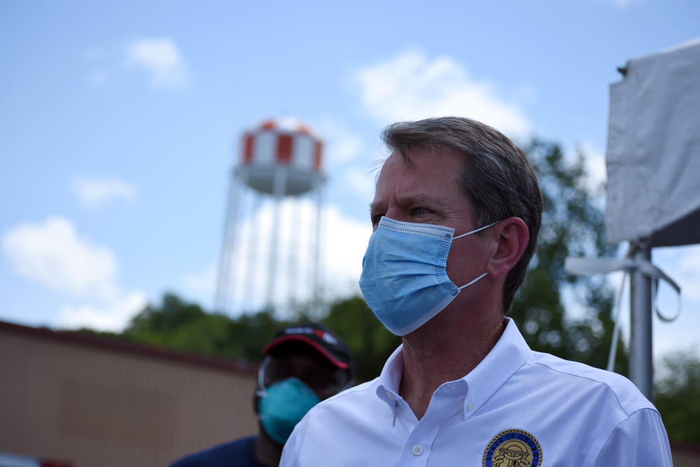 Gov. Brian Kemp stands at a COVID-19 testing site in Gainesville.