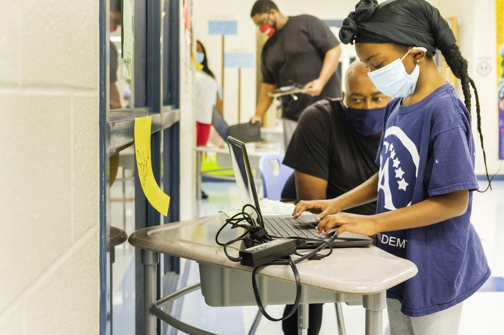 A student at Heritage Elementary School in Macon logs into her school district supplied laptop recently. Bibb Schools will start the year fully online. 