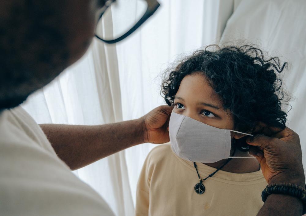 Man puts face mask on boy