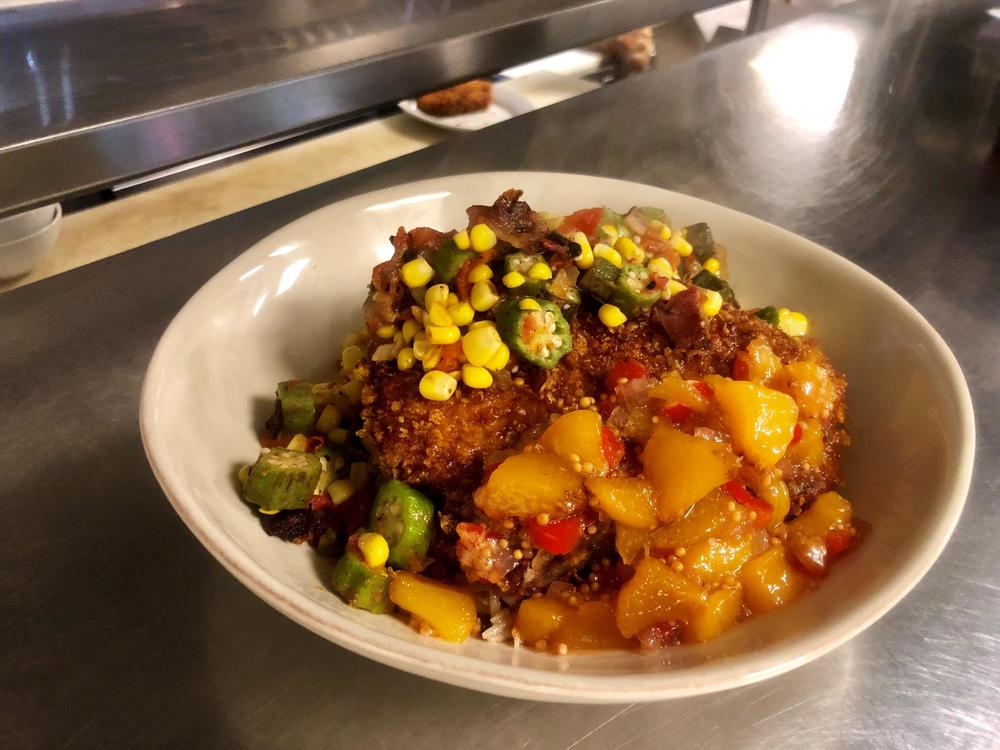 Crusted porkchop, topped with succotash and drizzled with peach murstada.