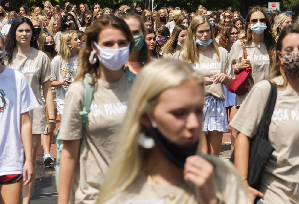 University of Georgia students participating in fall sorority rush cross Lumpkin Street in the heart of campus a few days before the start of fall 2020 classes. 