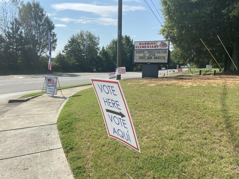 A sign points to a polling location in front of an elementary school.