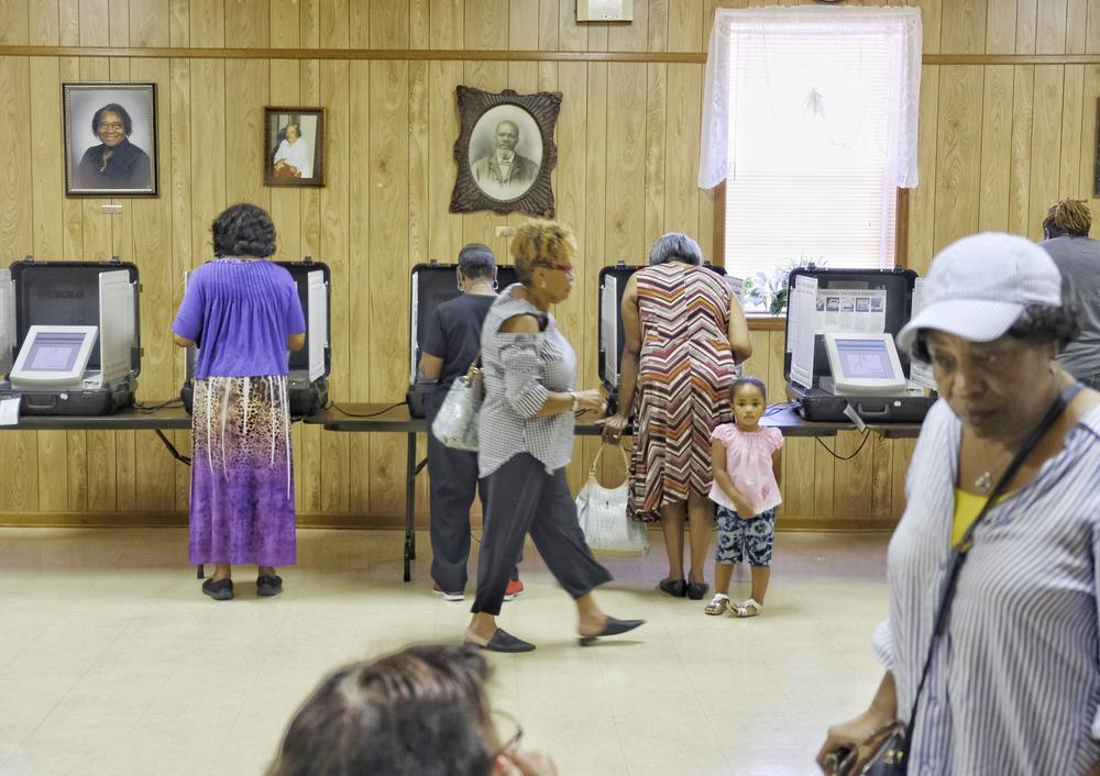 Voters inside of a polling station vote cast their ballots.