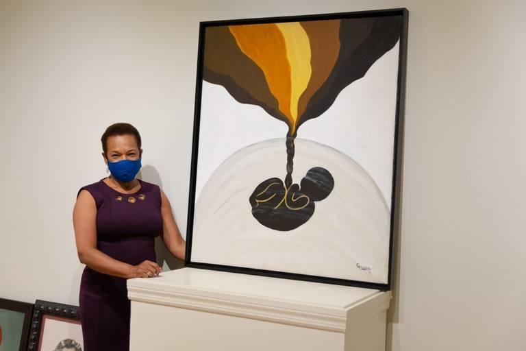 Gwendolyn Payton stands beside her painting “Rebirth of Colored Folks.”