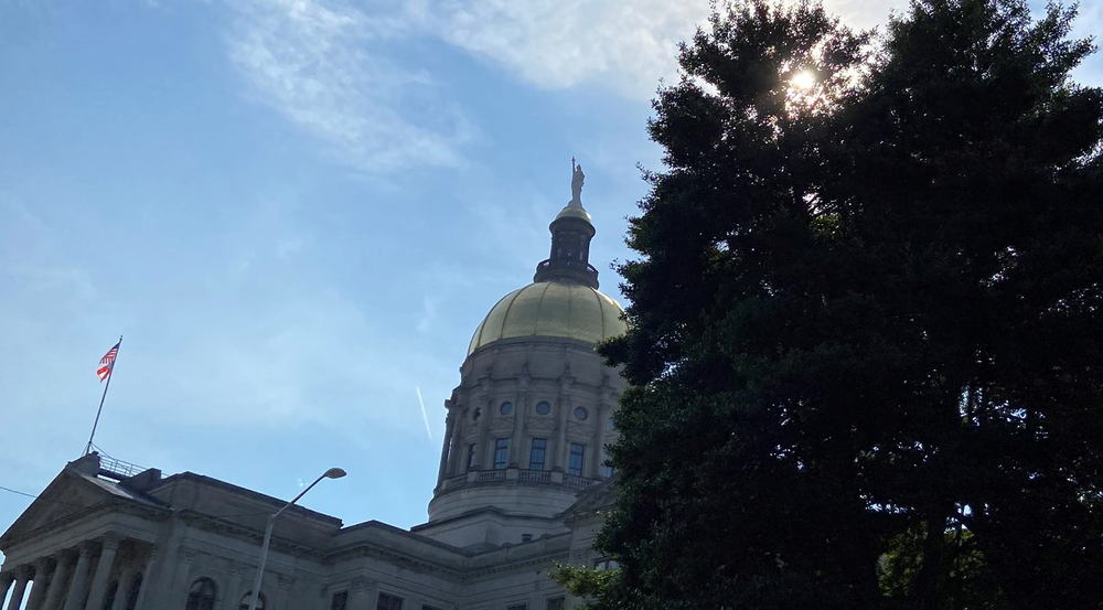 The Georgia state capitol peeks out from behind the trees in Atlanta Georgia.