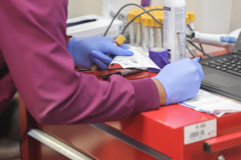 A medical technician records details about Nikeira Hall's blood sample, given as a part of the Augusta University antibody study in Dougherty County. 