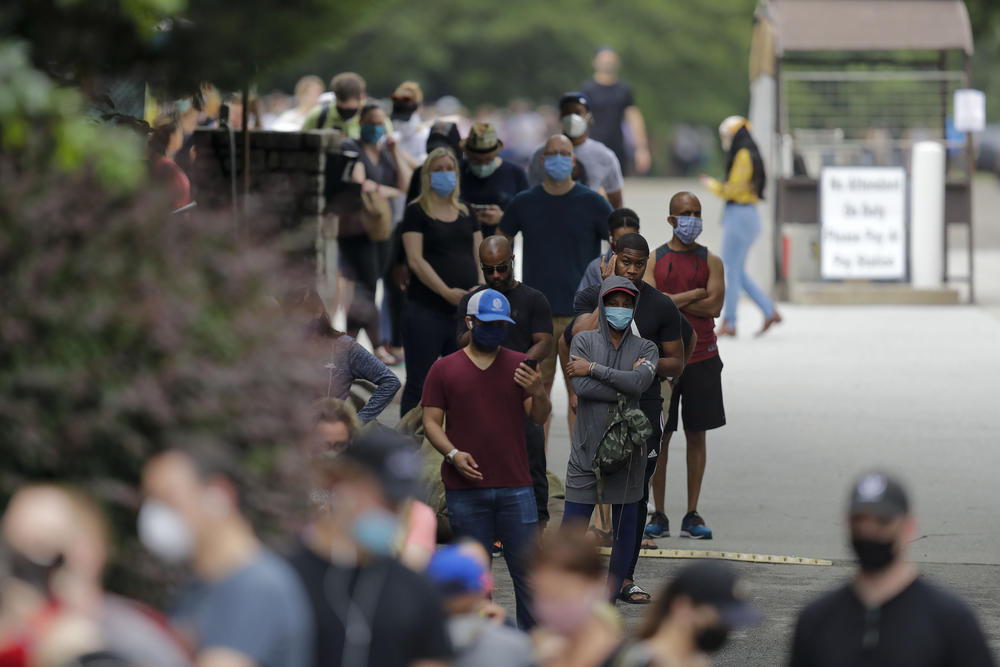 In this June 9, 2020 file photo, people wait to vote in the Georgia's primary election at Park Tavern in Atlanta. Twice delayed because of the coronavirus pandemic, Georgia’s primary earlier this year became a poster child for election dysfunction. 