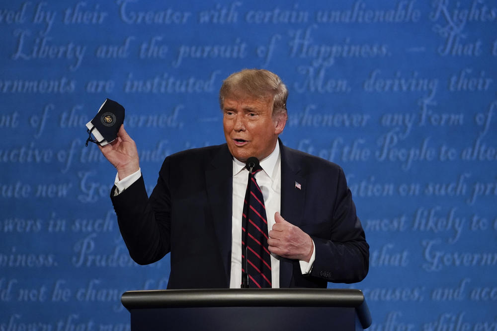Donald Trump holds up a mask on stage at the First Presidential Debate.