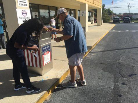 A poll worker assists a man with absentee ballots Friday at the Macon-Bibb County Board of Elections. 