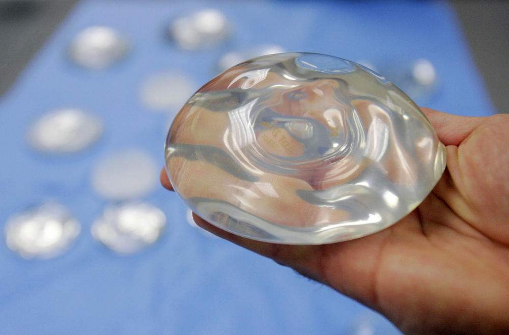 A breast implant held in a hand