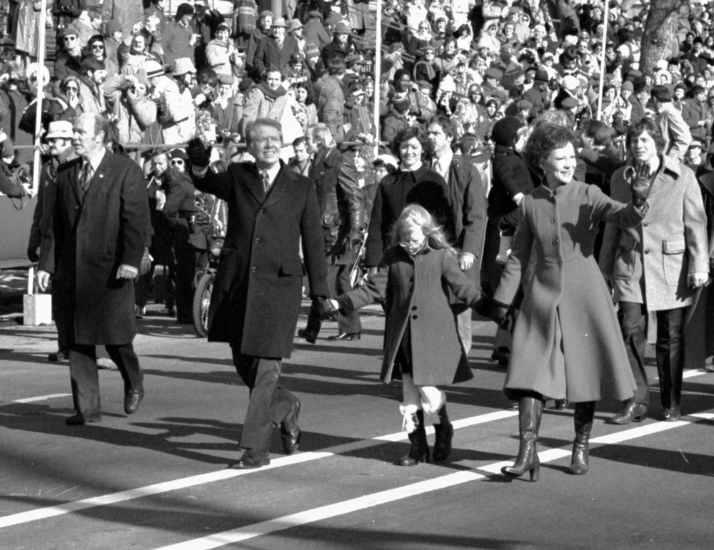 Jimmy and Rosalynn​ Carter hold hands of their da​ughter Amy, as they walk down ​Pennsylvania Avenue. Inauguration, January 20, 1977.  