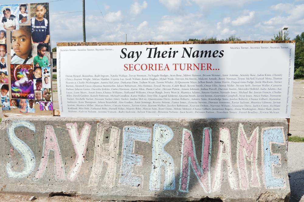 A "Say Their Names" paperboard.