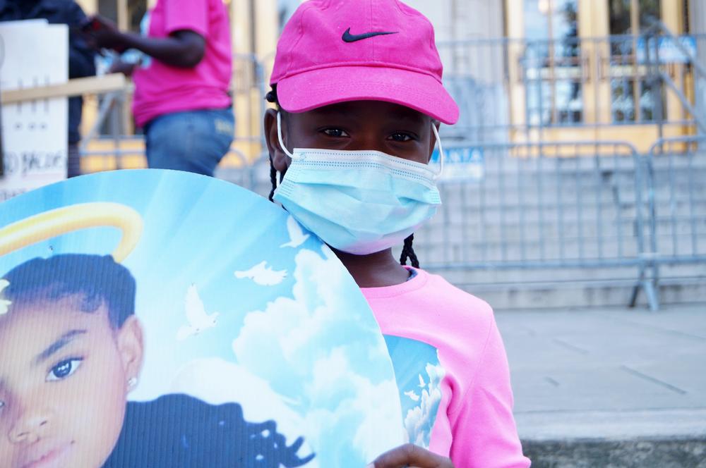 Malia Morton holds a Secoriea Turner sign.