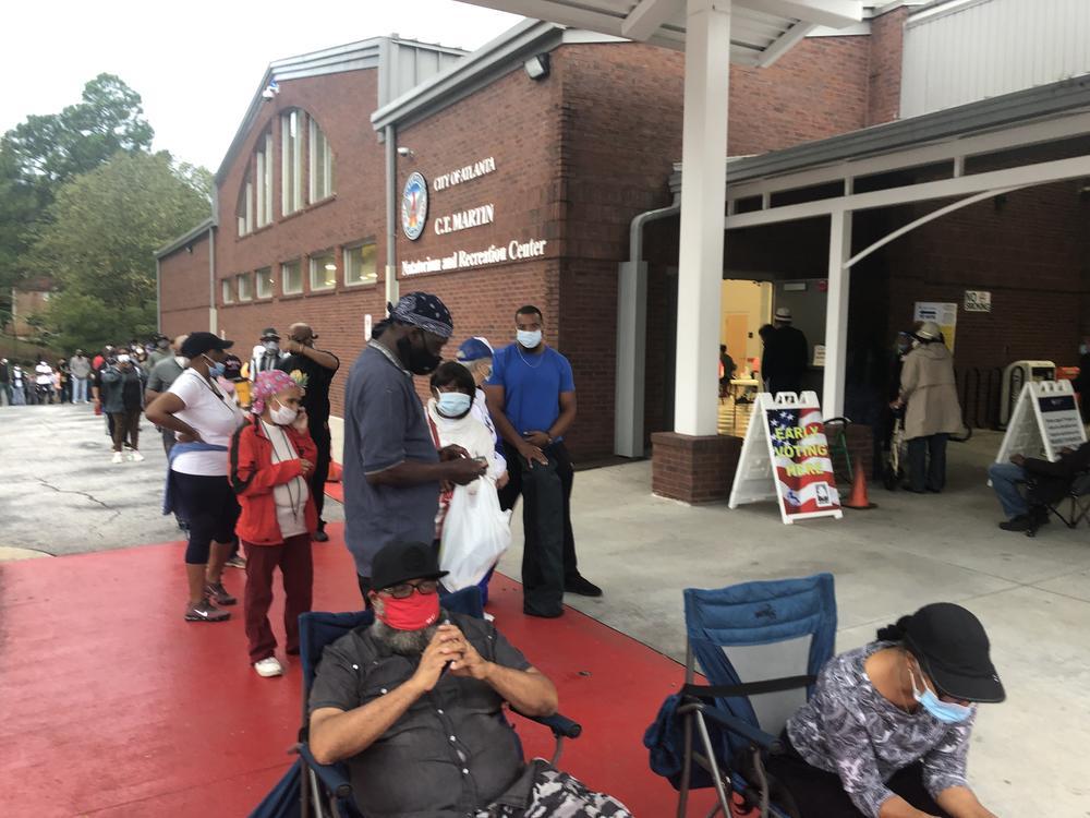 Voters arrived as early as 5:30 a.m. outside the Fulton County voting precinct at C.T. Martin Natatorium and Recreation Center on Monday, Oct. 12, 2020.