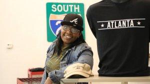 Chandra Moye poses for a photo in her store, Rock Steady Souvenirs and Gifts, in downtown Stone Mountain. The business owner says protests and counter protests have scared away customers and hurt the local economy. 