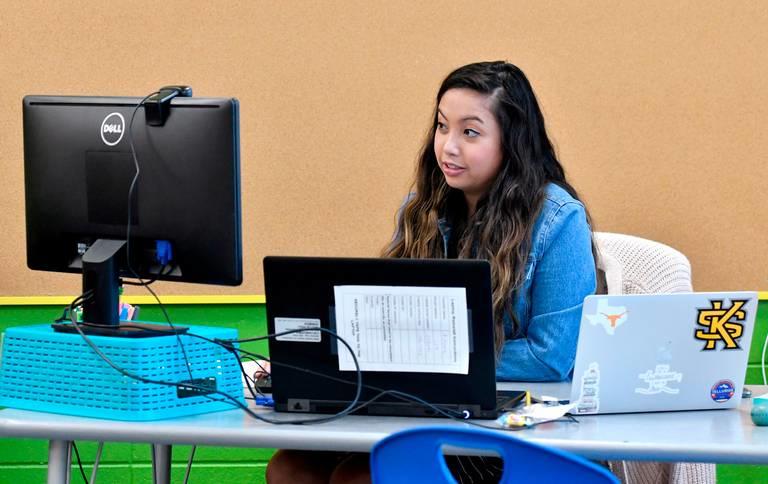 Veterans Elementary third grade teacher Angel Harris uses a three monitor/two computer set up to help keep an eye and teach her students Tuesday during the first day of virtual learning for Bibb County Schools. 