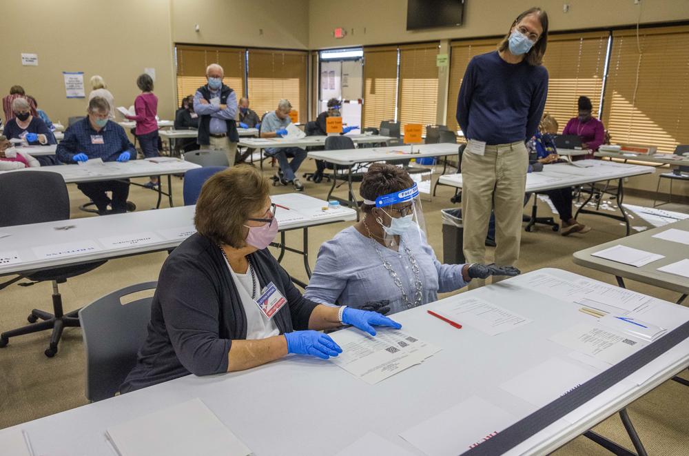 A poll watcher, right, and an auditing team, left, in the Bibb County Board of Elections in Macon on Monday, November 16. 